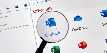 Magnifying glass zooming in on Microsoft graphic on computer screen