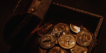 Chest in shadowy light with Bitcoins spilling from it