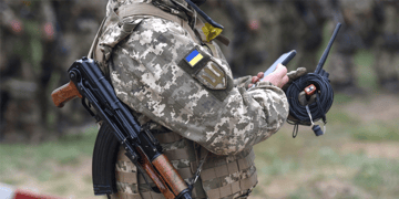 Soldier with a smart phone and a gun