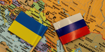Ukrainian and Russian flags seen on a map