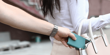 Glamorous woman having her mobile phone stolen from handbag
