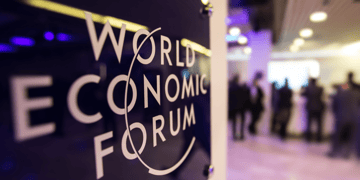World Economic Forum signage with blurred delegates in background