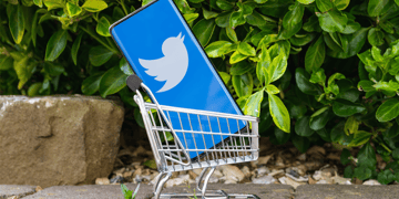 Smartphone with Twitter logo placed in a miniature shopping cart