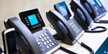 Row of digital landline handsets, such as are used in call centers