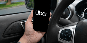 Driver holding phone in stationary vehicle.