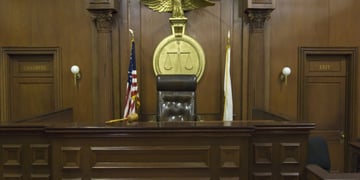 Empty courtroom with chair of judge and flags