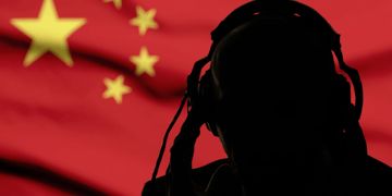 Silhouette of man on headphones against Chinese flag background