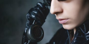Girl hacker with matrix-type suite with an oldschool phone