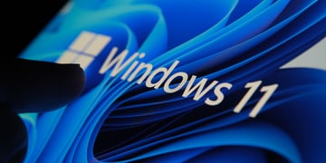 Shadowy hand touching a Windows 11 screen