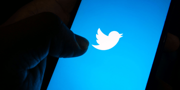 Generic pic of hand holding cellphone with Twitter logo