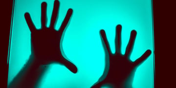 Hands behind a computer screen