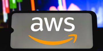 AWS logo on mobile held by silhouetted hand