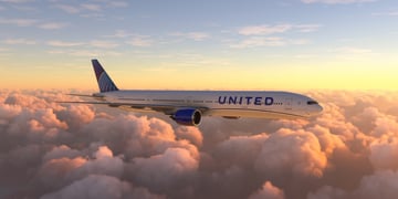 United Airlines Boeing jet flying above clouds
