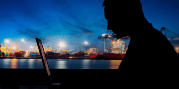 Hacker in front of a shipyard