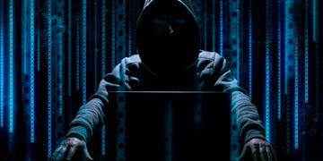 Shadowy hacker with binary screen in background