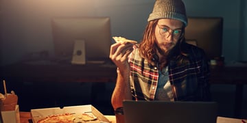 Man eating pizza, computer, work