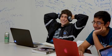 Two male students using laptops