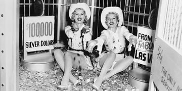 Two beautiful women sitting on silver coins