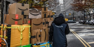 Amazon worker pulls packages on cart in New York City