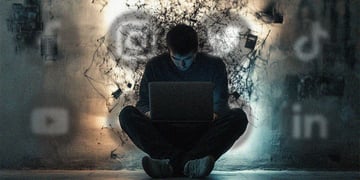 A man hunched over a laptop.