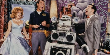 Characters on a retro TV show laughing with a robot.