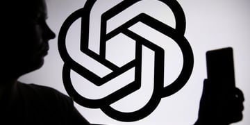 Someone talking a selfie next to the OpenAI logo in silhouette form.