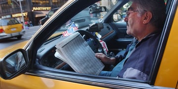 Cab driver reads a newspaper