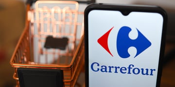 carrefour logo on mobile screen, shopping cart in background