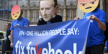 Protestors against Facebook, wearing Mark Zuckerberg and angry face masks.
