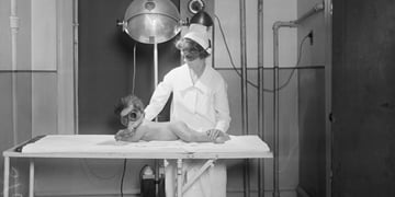 A retro nurse examining a baby.