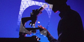 A scientist looking at an intercrystal under a microscope