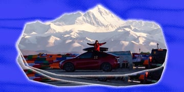 Tesla with a woman sitting on top of it, Mount Everest in the background
