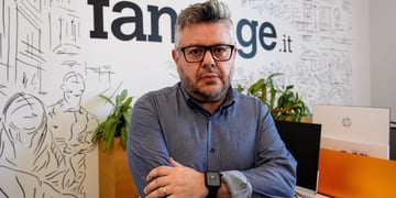 italian man with glasses and dark blue shirt with arms crossed and glasses, grey hair