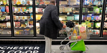 Co-op store inside, black man, fridge, frozen food, pizza, cart