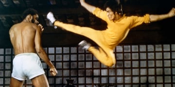 Bruce Lee doing a flying kick.