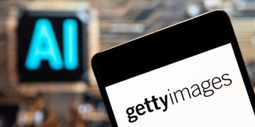 Getty images written in black on white telephone screen, AI blue sign in the back