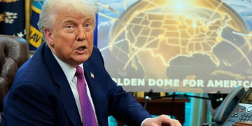 donald trump in blue suit, purple tie, shite shirt neext to golden dome