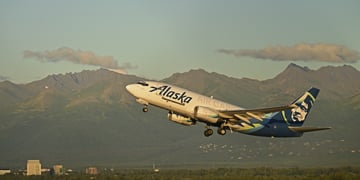 white plane taking off, blue tail with white face, Alaska air craft