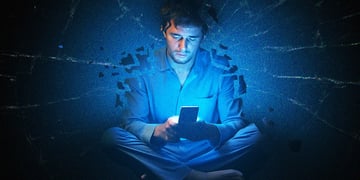 Someone scrolling their phone at night, with a broken background (could be glass).