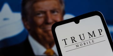 blonde old man in the back, orange tie, trump mobile on white smartphone screen