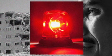 A red siren, mounted on top of an affected victim of an earthquake, and damaged building.