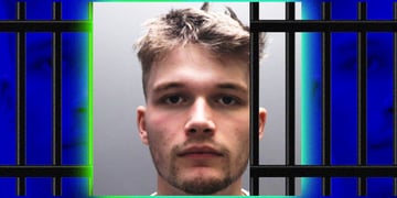 young blond man in grey-ish picture with jail bars around him
