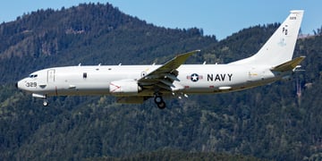 Military plane in air with US Navy logo