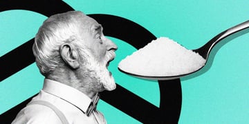 An elderly man trying to eat a huge out of proportion spoonful of salt.