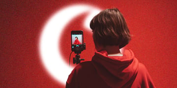 A virtual influencer looking into a phone on a selfie stick with the Vodaphone logo present.