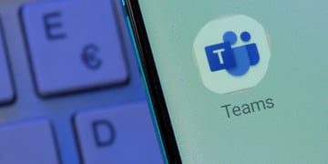 A logo of Microsoft Teams with keyboard in the background