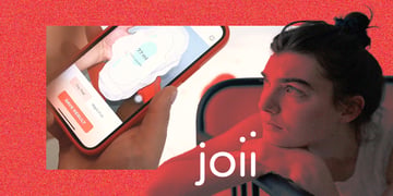 A woman looking at Joii period app on her phone