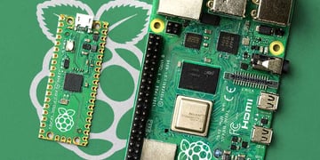 RaspberryPi logo, chips, green background, inside of computer