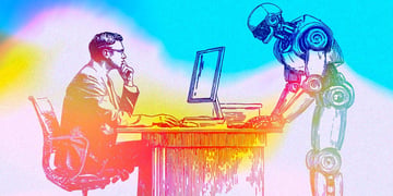 A person sitting at the desk looking at the computer screen and a robot working