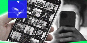 A smartphone screen in grayscale mode, person using phone in bed